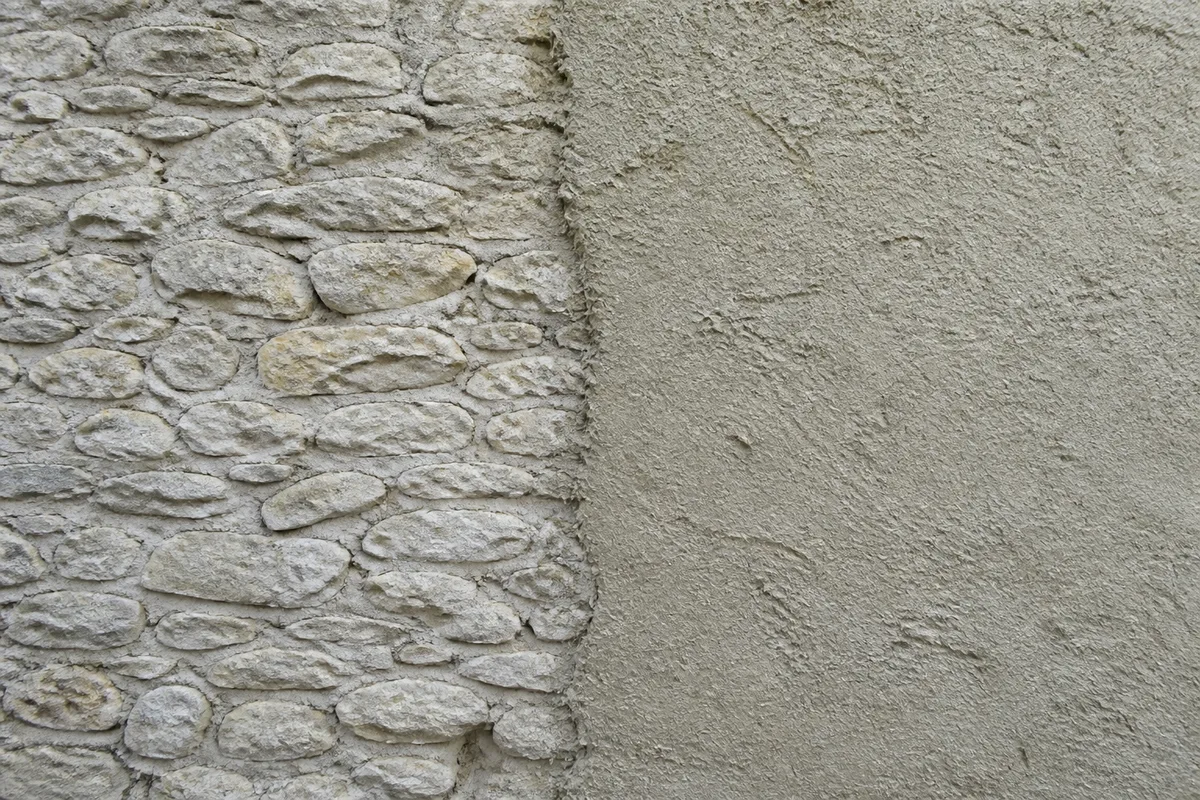 Mur en pierre partiellement recouvert d&rsquo;un enduit chaux chanvre frais